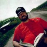 Michael Hart with Book, in cap and red shirt